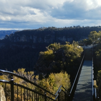 Between The Great Rocks, betwixt Olympian Rock and Tarpeian Rocks, Leura, with a metal path beading from the front to the right which overlooks the Three Sisters to the left in the distance