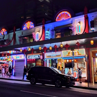 Light-Up Nightlife, Burwood Chinatown, Burwood, with a multitude of multicoloured neon signs against a row of two story buldings which include words for food vendors and the name of Burwood Chinatown