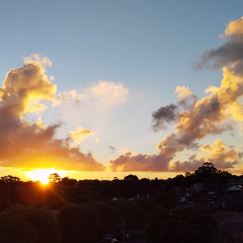 Orange Glow, Dulwich Hill, with an orange sun on the horizon causes half the grey clouds to turn orange